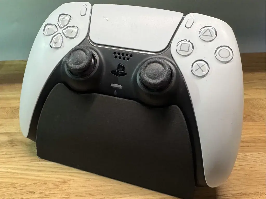 Λευκό χειριστήριο PlayStation σε μαύρη βάση από μπροστά