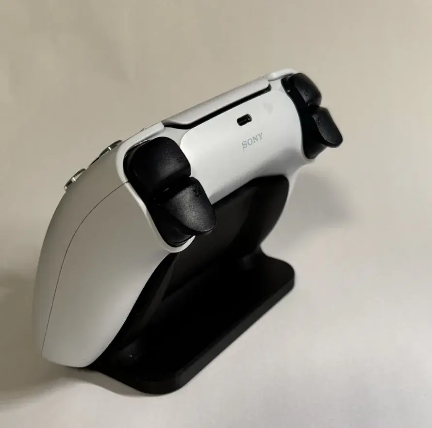 Λευκό χειριστήριο PlayStation σε μαύρη βάση από πίσω